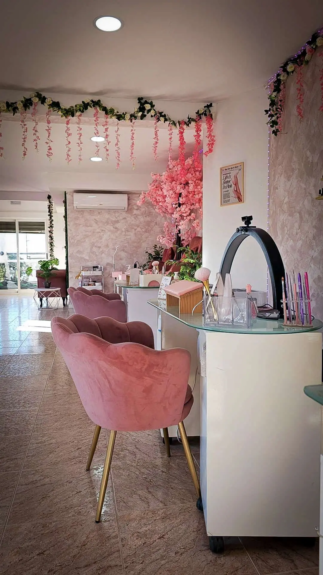 Zona de trabajo del salón Iris Nails con sillones rosa y flores